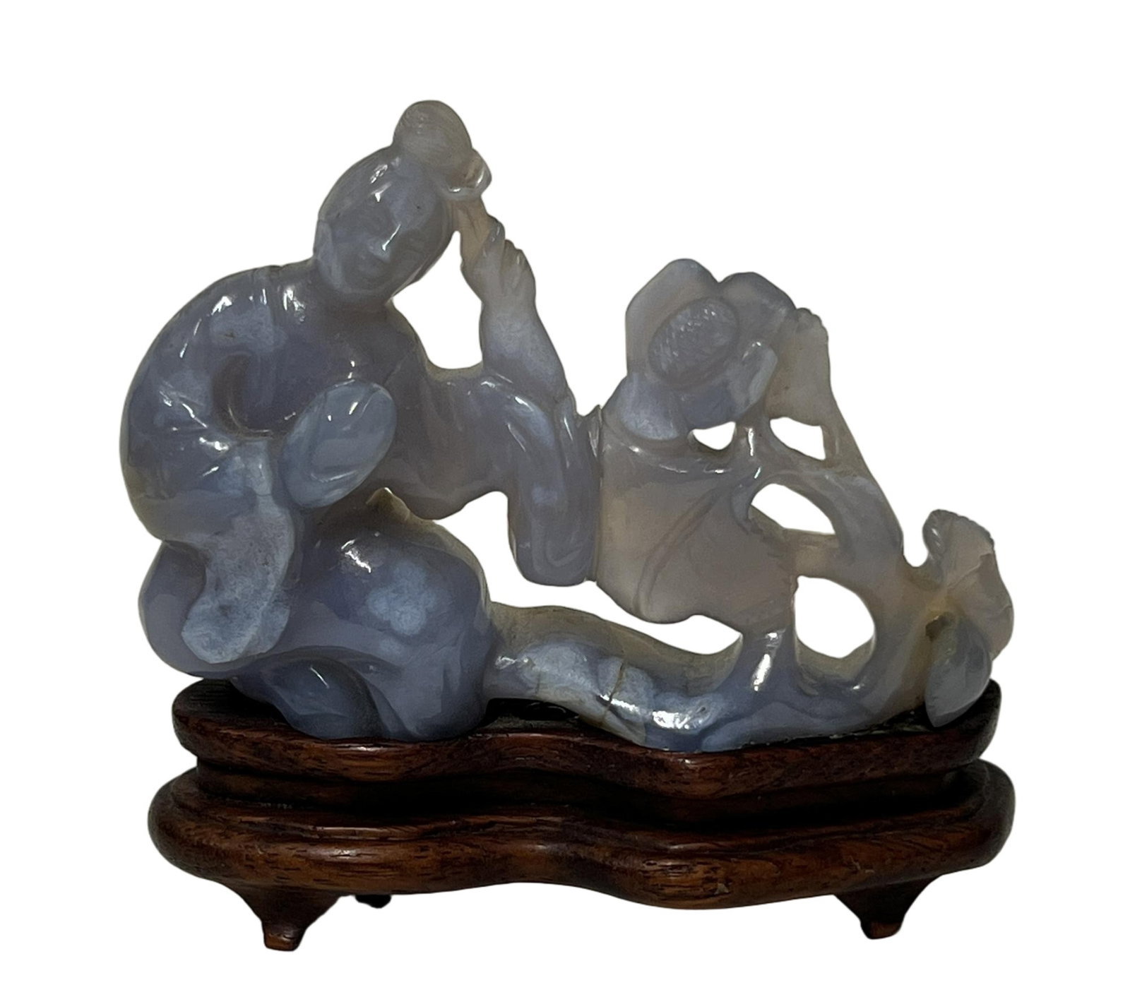 A CARVED AGATE LONG ELIZA: A CARVED AGATE LONG ELIZA Carved and reticulated with Long Eliza, the stone is of purplish gray tone. DIMENSION: Total H. 8.5 L. 8.5 cm. A LIST OF RECOMMENDED THIRD-PARTY SHIPPER IS AVAILABLE UNDER