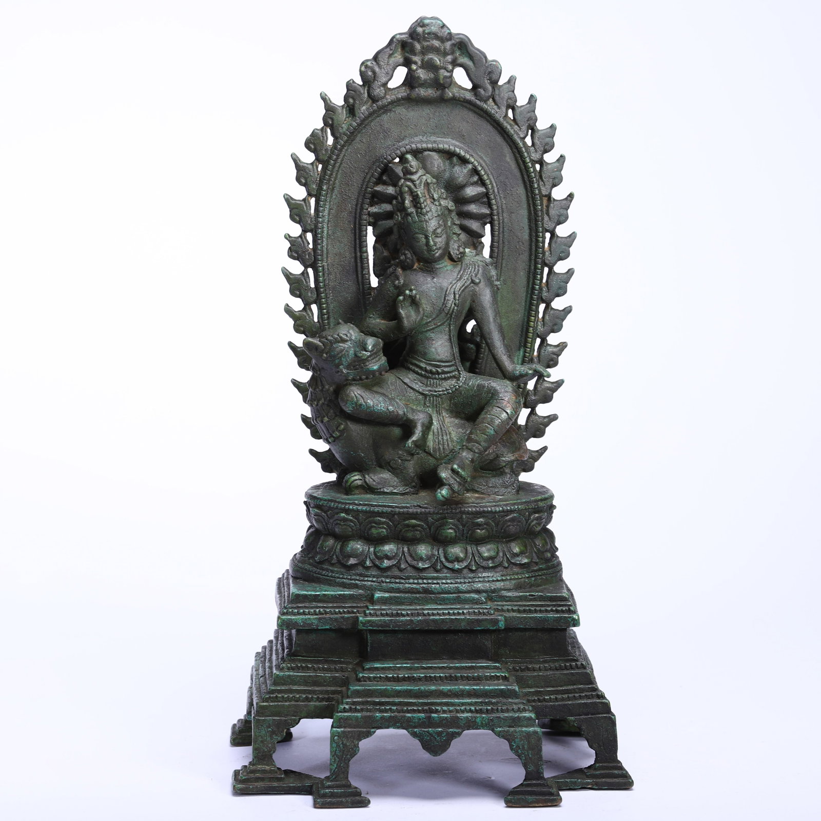 A BRONZE FIGURE OF AVALOKITESVARA: A BRONZE FIGURE OF AVALOKITESVARA Seated with his right knee up on a lotus base with offset petals and holding a lotus stem in the left hand, wearing a striped dhoti with a stippling pattern. DIMENSIO