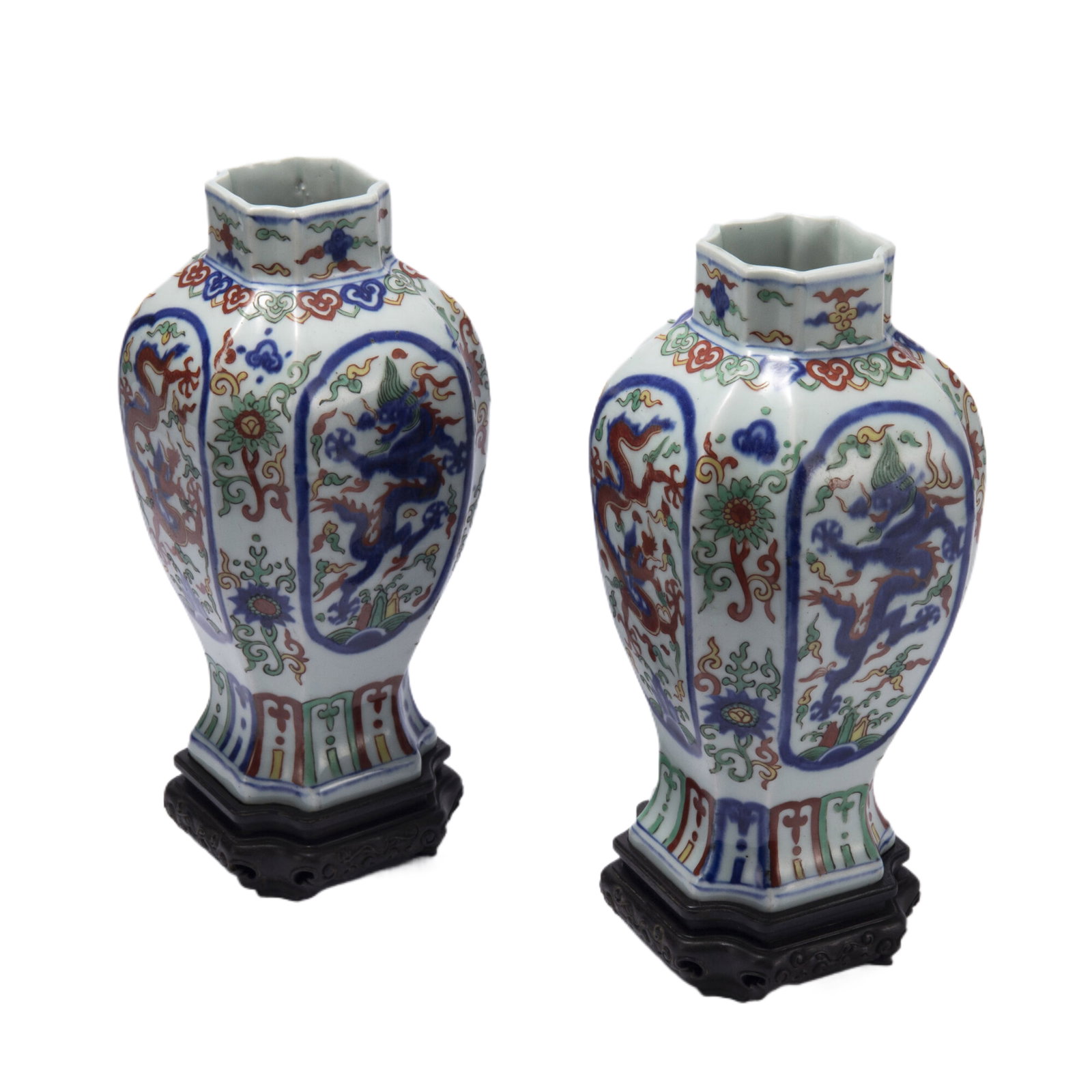 PAIR WUCAI GLAZE DRAGON PORCELAIN VASES: PAIR WUCAI GLAZE DRAGON PORCELAIN VASES The faceted baluster sides decorated with leaping dragon above foaming waves and rock, lotus-lappets bands at the rim. DIMENSION: L. 12 cm. W. 12 cm. H. 28.5