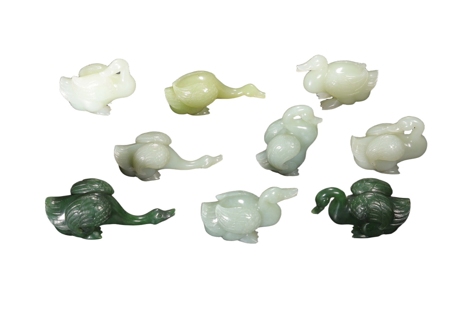 A GROUP OF CARVED JADE GEESE: A GROUP OF CARVED JADE GEESE in a collection of nine items, each carved in round, with curved neck and feather detailed wings. DIMENSION: L. 9 cm. W. 3.5 cm. H. 4.5 cm. A LIST OF RECOMMENDED