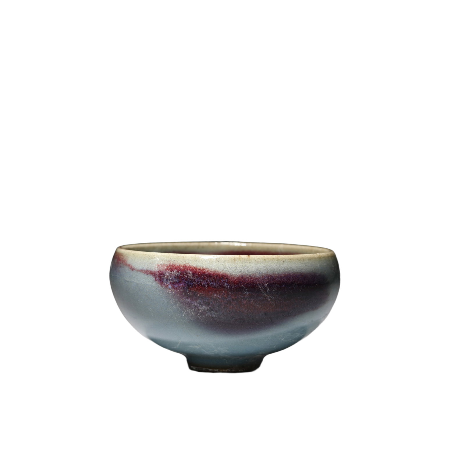 A JUN-WARE TEA CUP: A JUN-WARE TEA CUP Sturdily potted with deep rounded sides rising from a short foot to the slightly incurved mouth rim, the bowl is covered with a thick glaze of milky-blue tone thinning to mushroom