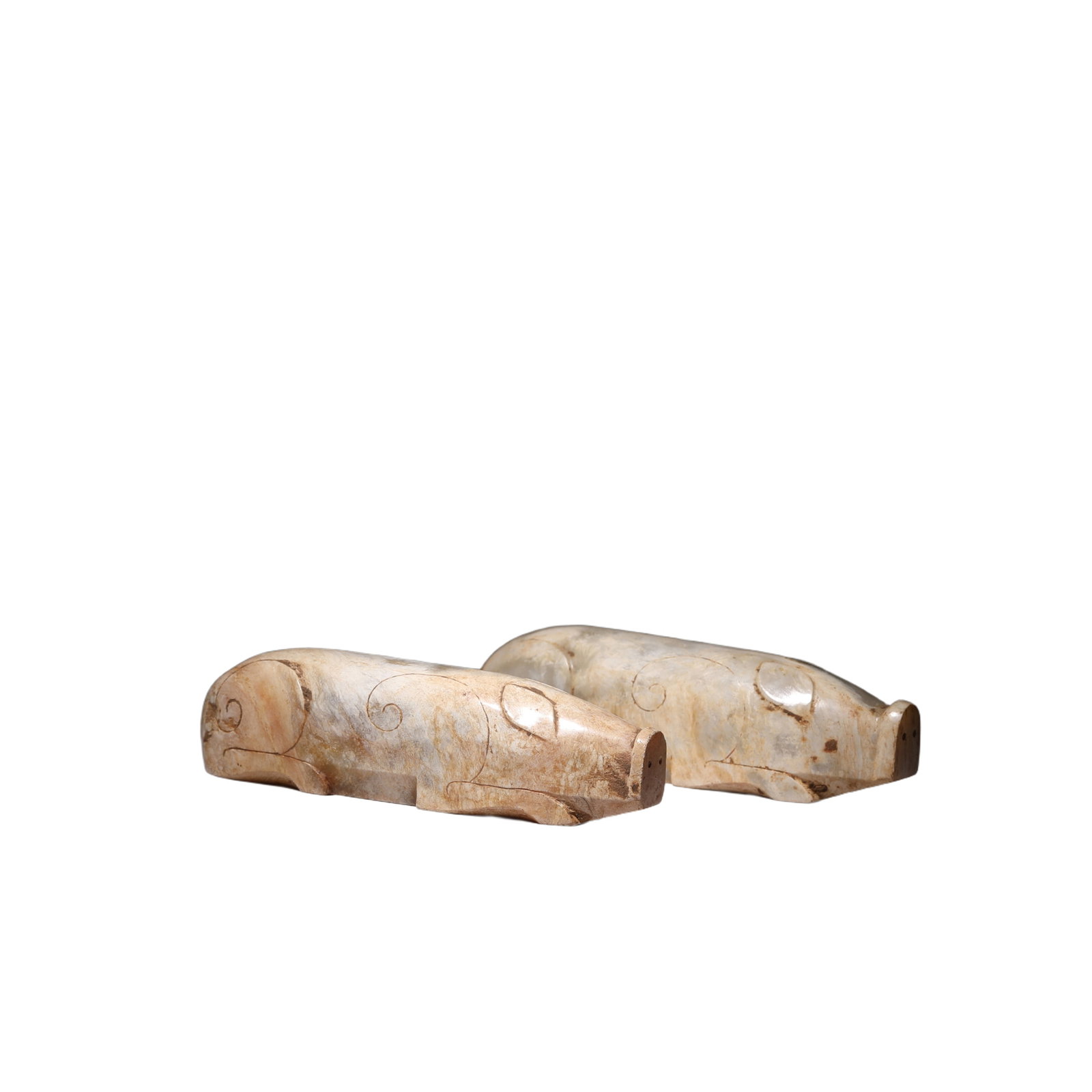 PAIR CARVED WHITE JADE PIGS: PAIR CARVED WHITE JADE PIGS Each rounded, rectangular block is carved as a recumbent pig with flat snout above a pierced narrow tab, and deep, slanting grooves that delineate the ears, the front and r