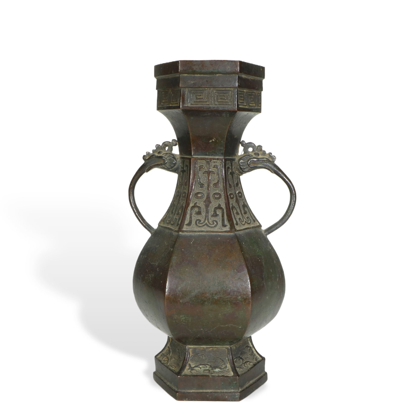 A BRONZE HEXAGONAL VASE: A BRONZE HEXAGONAL VASE Of hexagonal pear shape, flanked with dragon heads handles at the neck, with oxidize marks. DIMENSION: HEIGHT: 31cm WIDE: 15cm A LIST OF RECOMMENDED THIRD-PARTY SHIPPER IS AVAI
