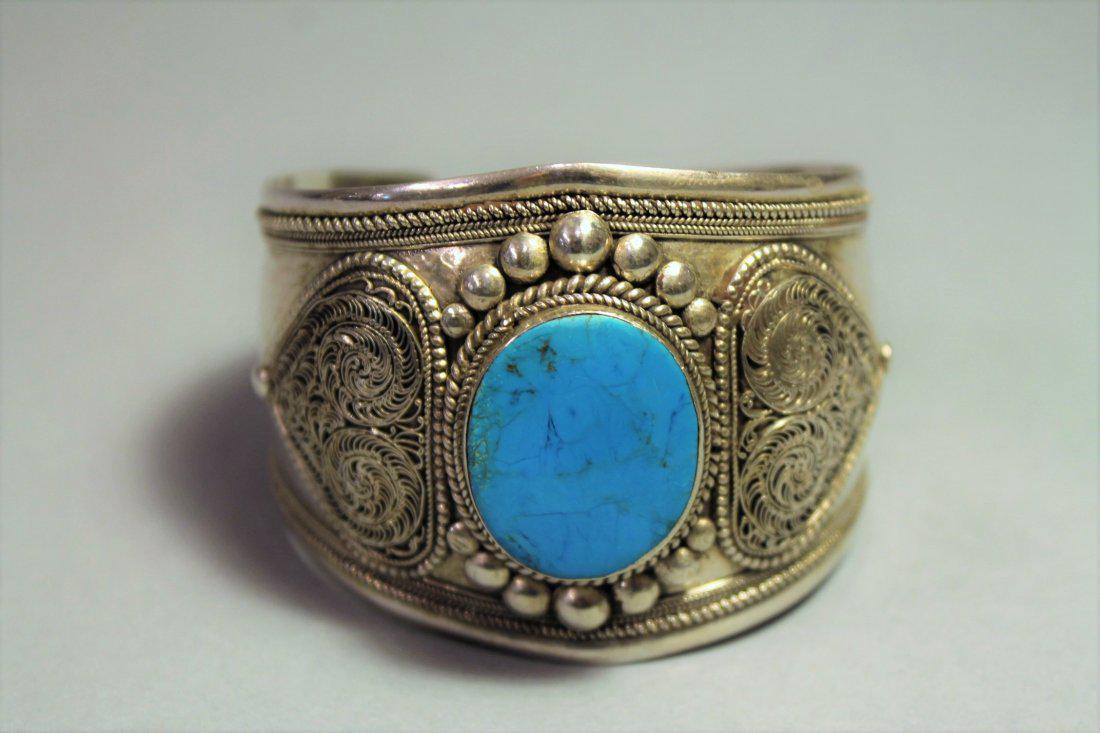 Sterling Silver and Turquoise Cuff Bracelet Native Am: Sterling silver and turquoise cuff bracelet with center turquoise stone and intricate filigree detail. This piece is part of a collection purchase from David Saity, a New York jewelry dealer who trave