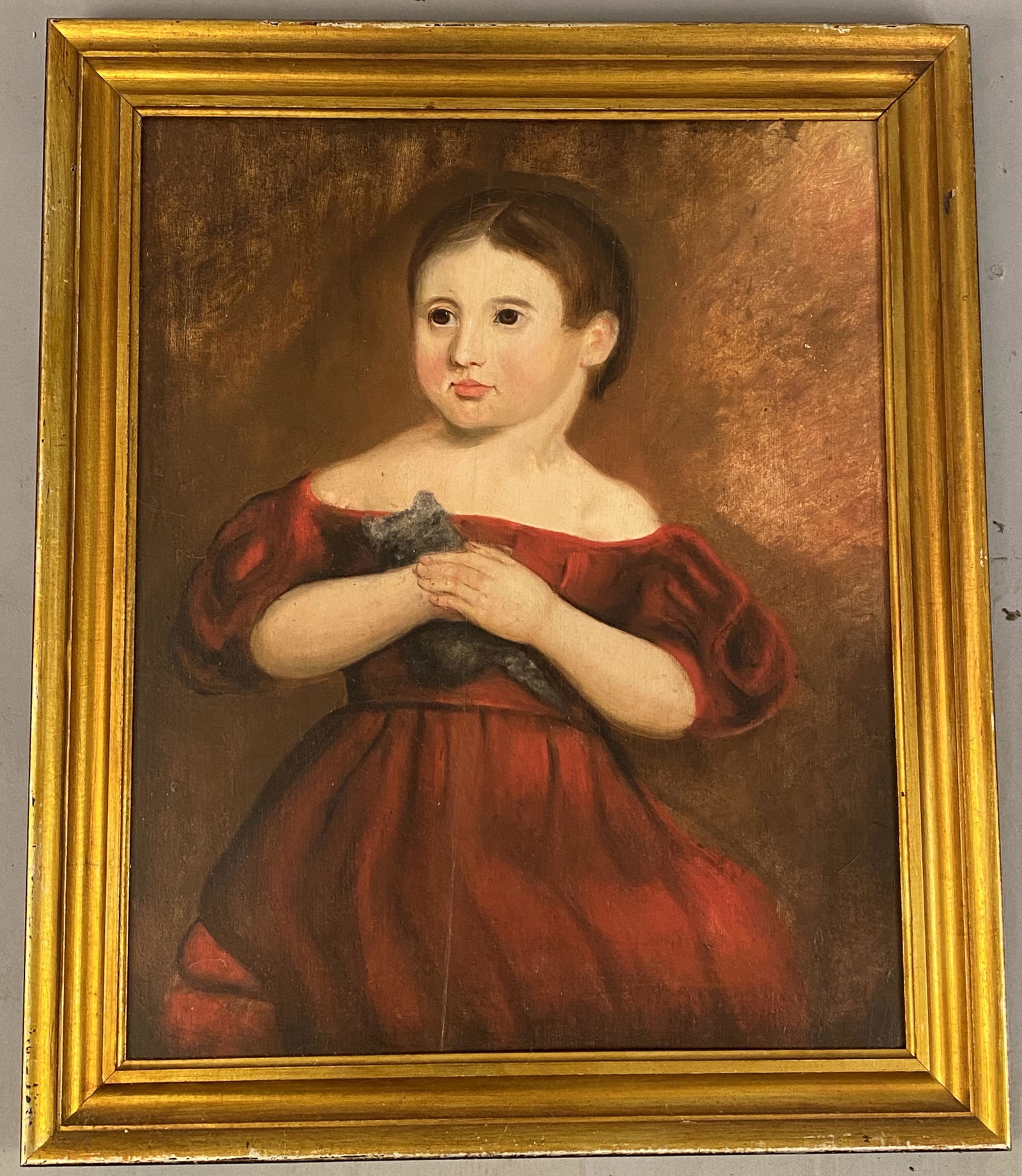 Primitive Portrait of Girl in Red Dress w/Kitten.: Oil on board, primitive portrait of girl in a red dress holding a kitten. Unsigned. A split in the panel has been glued. Frame 30 1/2" x 25 1/2", site 25 1/4" x 20 1/2"