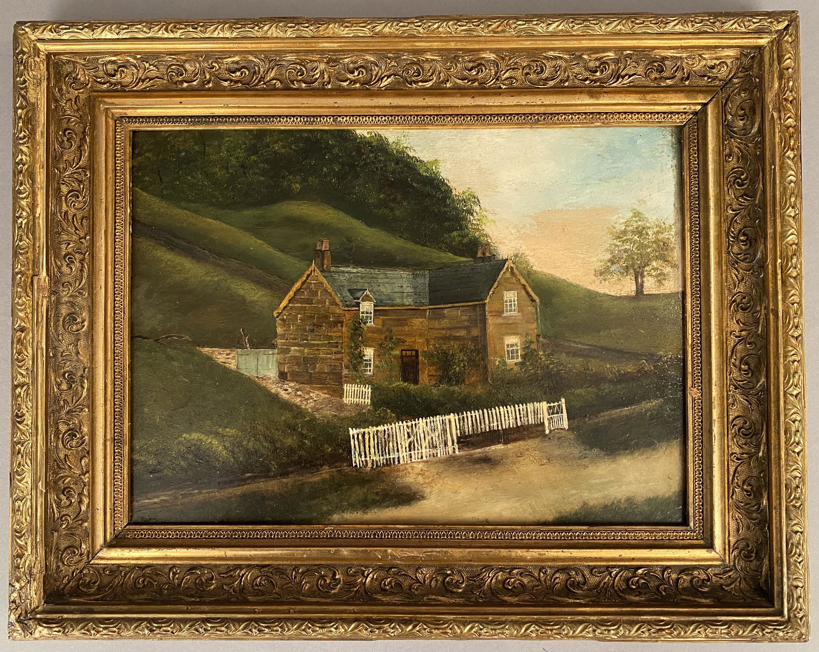 Primitive Oil on Board-House w/White Picket Fence: Primitive oil on board of a country house with a white picket fence with landscape background. Written on back, Thorn Treehouse, painted 13th March 1906. Frame 15 1/4" x 19 1/4", site 9 1/2" x 13 3/4"