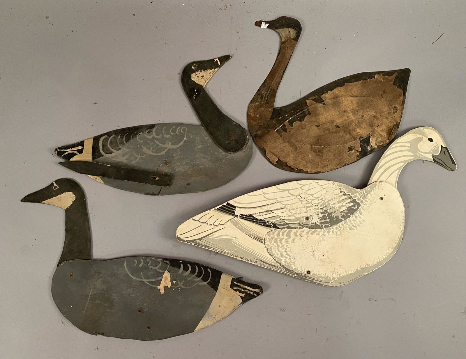 4 Flat Folding Duck Decoys w/Jointed Necks: Four flat, folding swan and goose decoys, one tin and the others wood. Jointed heads. The swan is marked A McKoy Decoy. Largest 28"