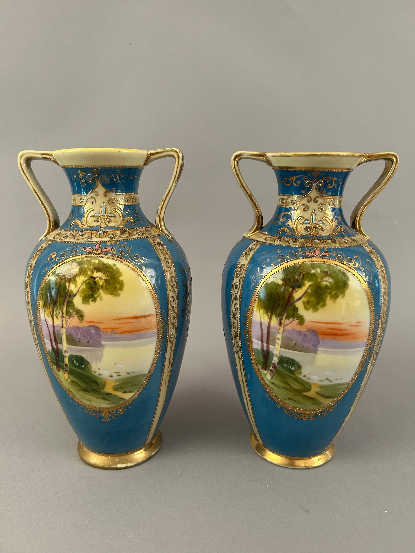 Pair Of Hand Painted Nippon Vases With Scenes Overlooking The Water: Pair of hand painted Nippon vases with scenes overlooking the water. Gold detail, some raised. Marked on the bottom.