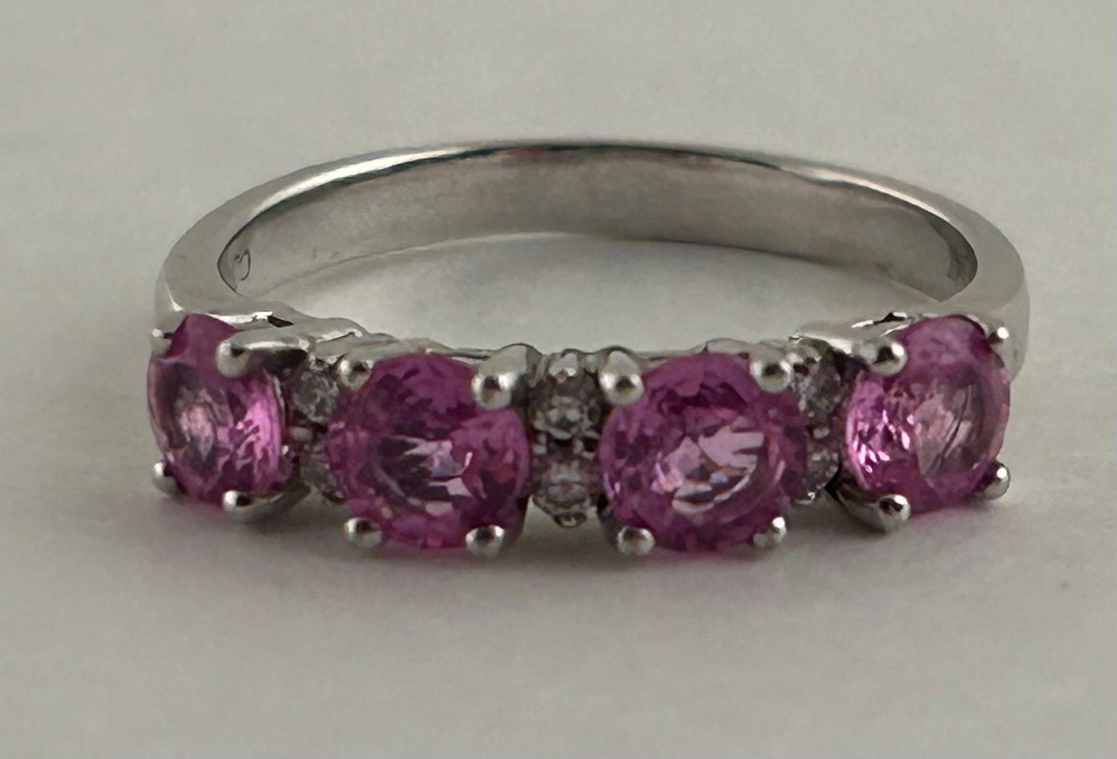 14 Karat White Gold Ring With Pink Sapphires And Diamonds: 14 Karat White Gold ring with pink sapphires with two small diamonds between each. Marked 14 K CJ Size 7