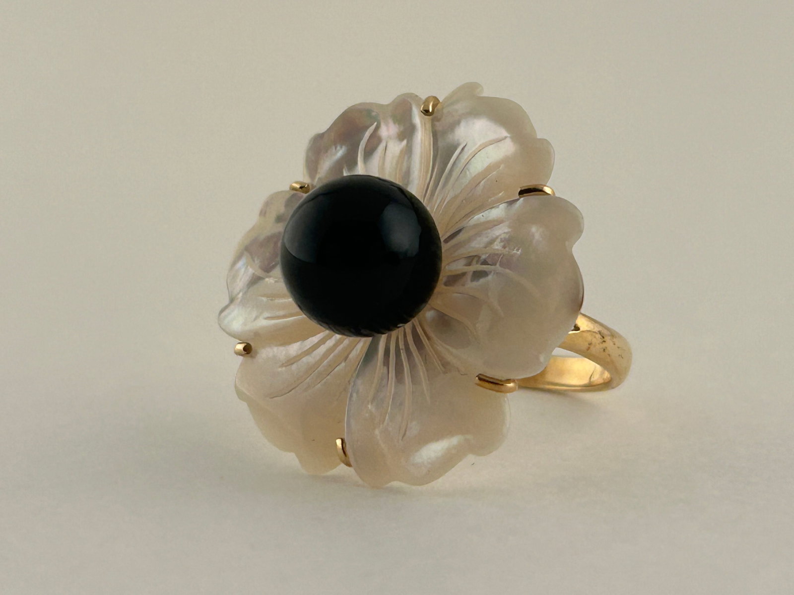 14 Karat Gold Ring W Mop And Black Pearl: 14 Karat Gold ring with carved Mother of Pearl flower and a Black Pearl in the center. Marked 14K China. Size 8
