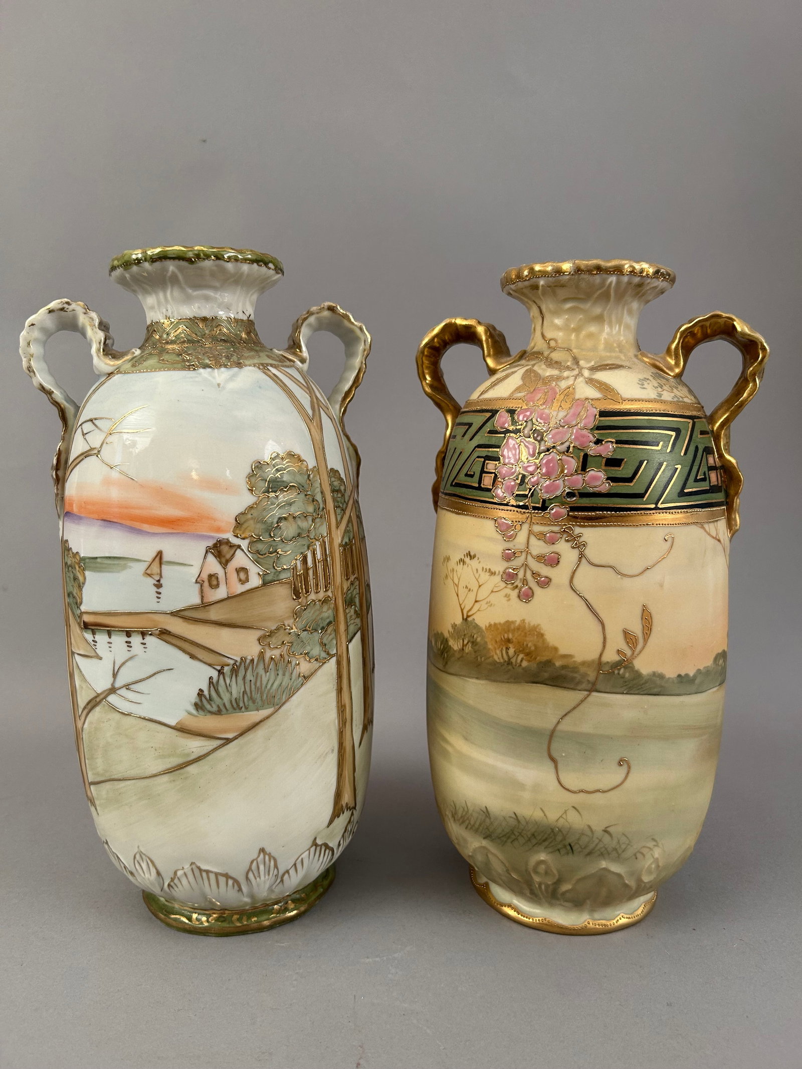 Two Hand Painted Nippon Vases: Two hand painted Nippon vases, one with a water scene and the other with a winding path and raised flowers. Raised gold accents on both pieces. Both marked on the bottom.