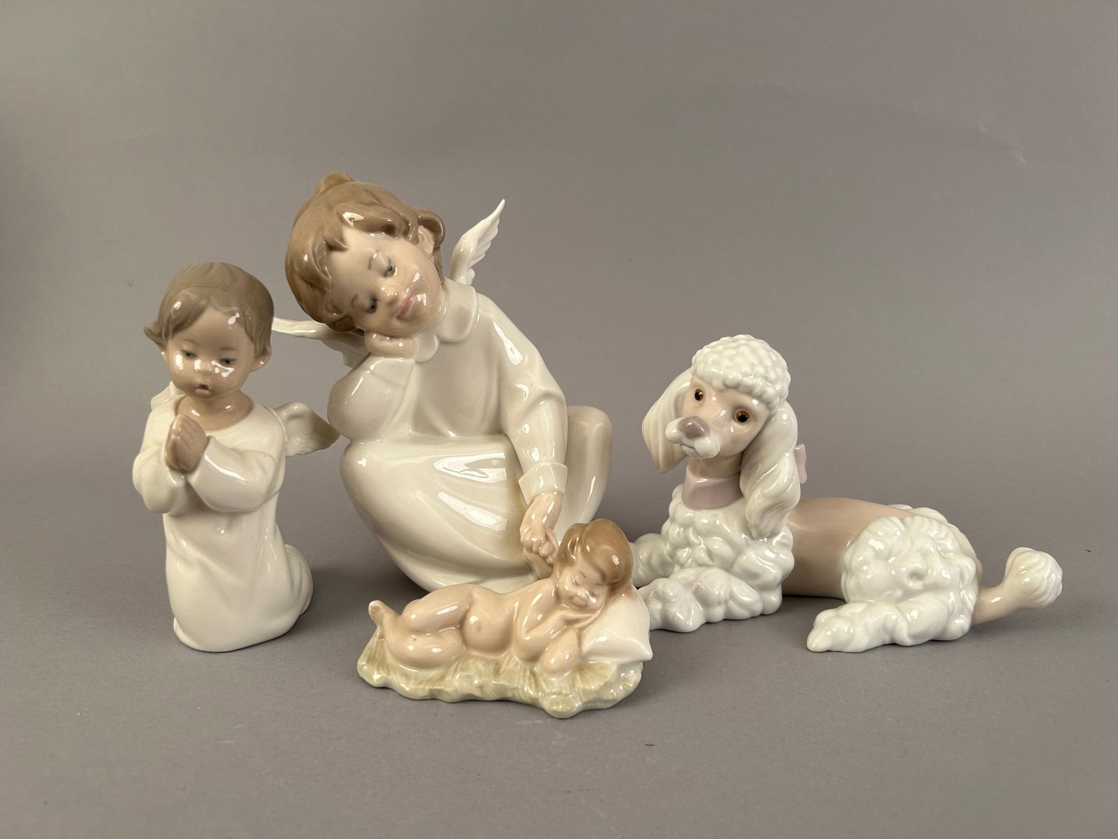 Four Pieces Of Lladro, Angels, Baby And Poodle: Four pieces of Lladro. Two Angel children, a sleeping baby and a poodle. All marked on the bottom.