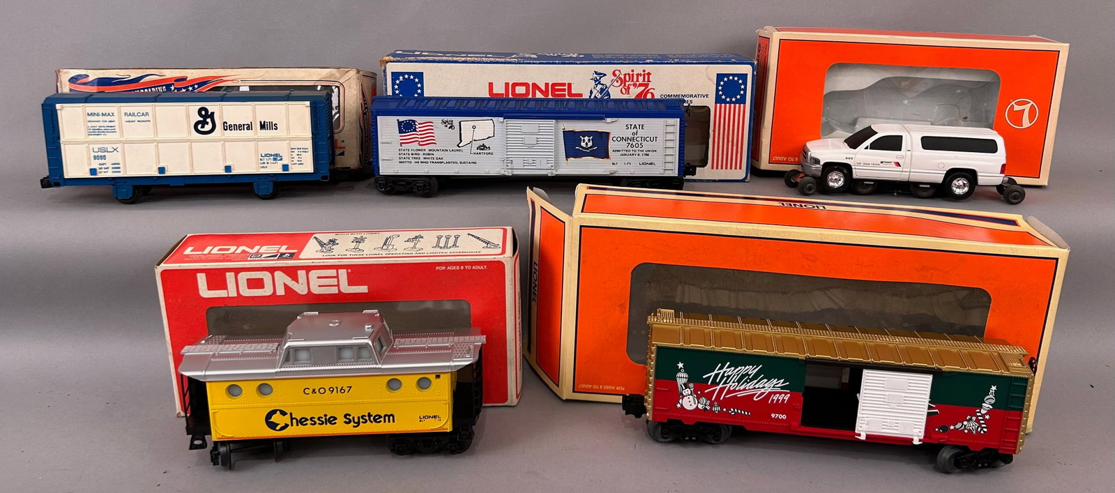 Five Lionel cars with Boxes O Gauge: Five Lionel cars with Boxes including C&O 9167 Chessie System Illuminated Caboose, 9700 Christmas 1999 Boxcar, 9090 General Mills Mini Max Box Car, 7605 Spirit of 76 State of Connecticut and 18440 New