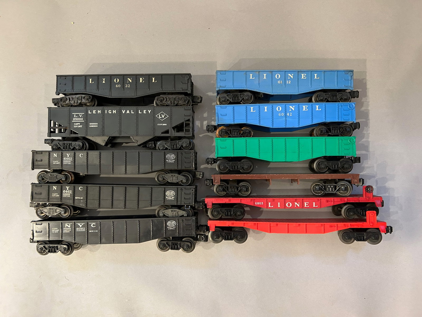Eleven Lionel train cars: Eleven Lionel train cars and flat beds including 6803, 6112, 6042, 6032, 6462 and 25000. O Gauge