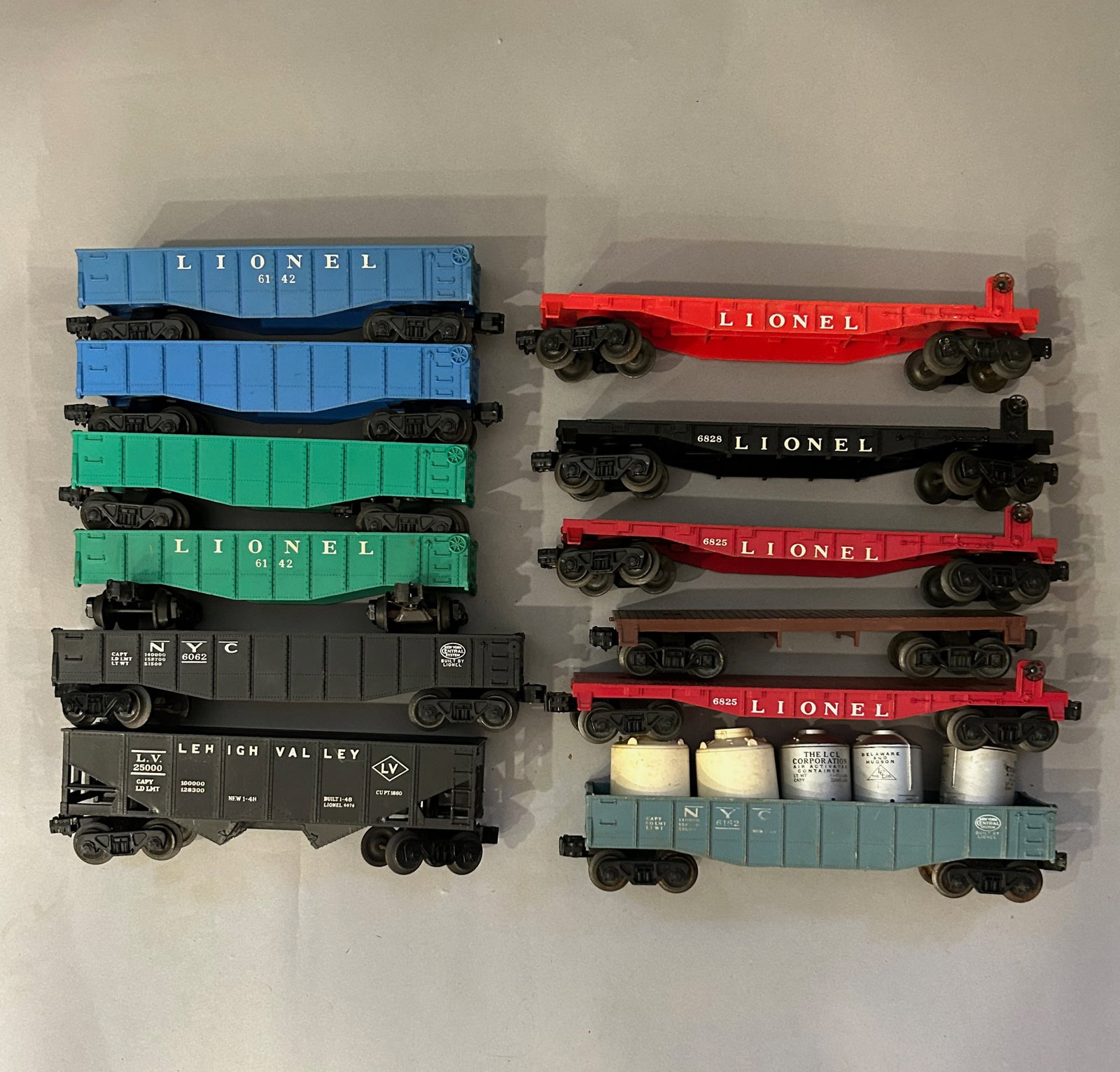 Twelve Lionel Train cars: Twelve Lionel Train cars and Flat Beds including 6828, 6825, 6142, 6062, 6162 and 25000. O Gauge