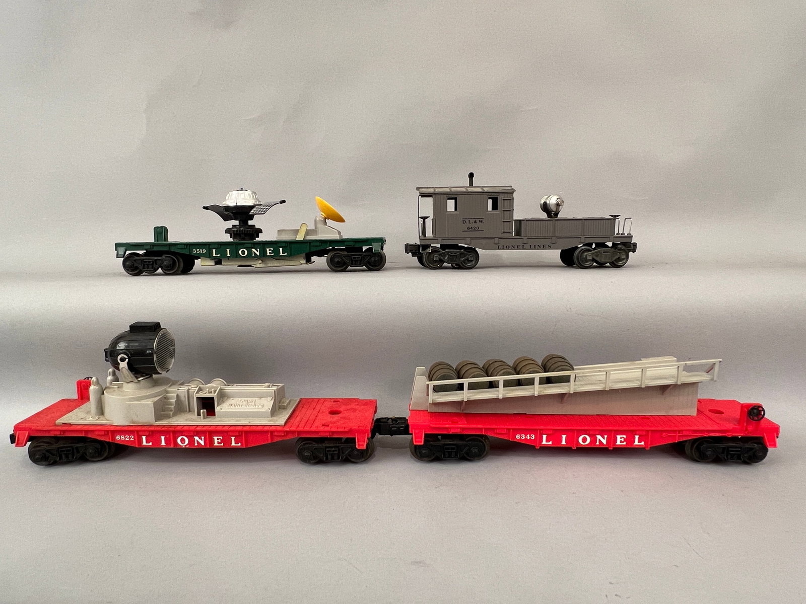 Four Lionel Train Cars O Gauge: Lionel Trains Working caboose 6420, Satellite Car 3519, Flat Barrel Car 6343 and Track Maintainance Car 6822. O Gauge