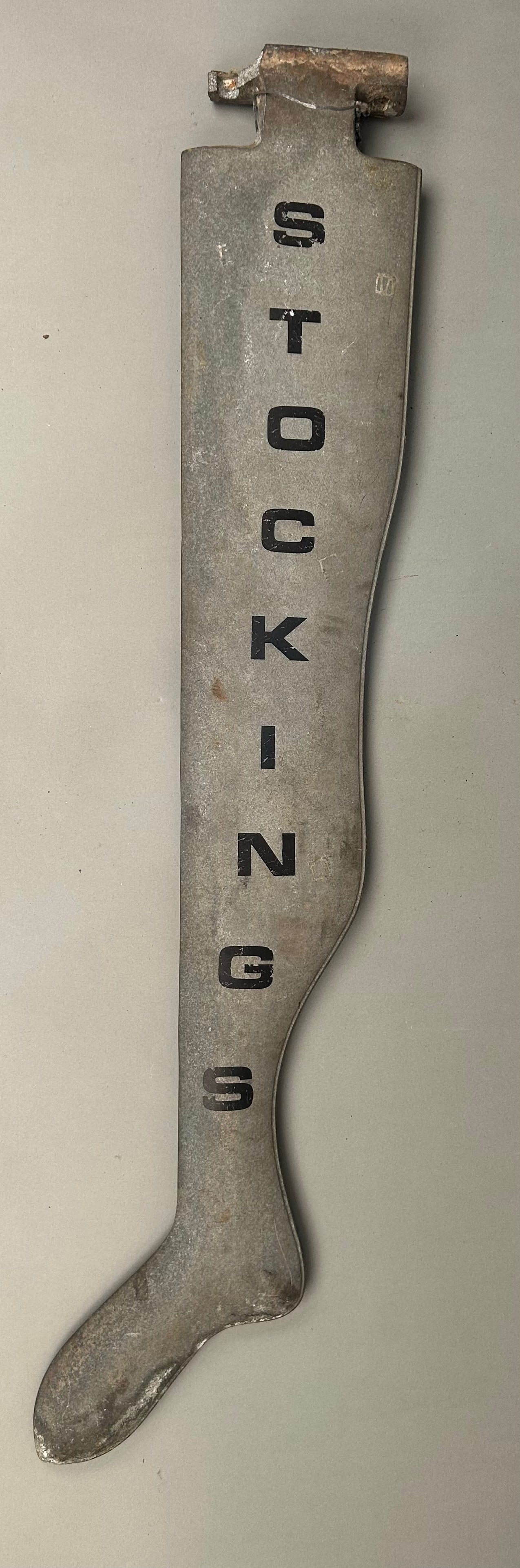 Vintage Stockings Trade Sign: Vintage "stockings" trade sign. Cast aluminum painted with black lettering. 42" tall. Damage to mounting bracket.Provenance: Robert and Jane Cottingham Collection Newtown, CT