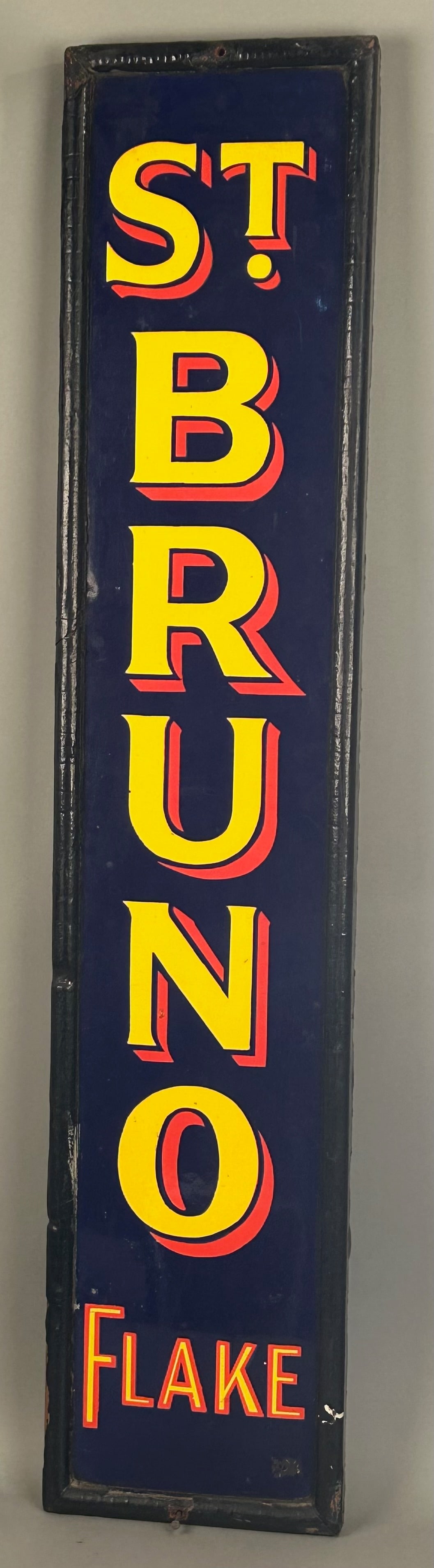 St. Bruno Flake Antique Porcelain Sign: St. Bruno Flake antique porcelain sign with original wooden frame bright vibrant blue background with yellow and red lettering. 48” x 10”. Provenance: Robert and Jane Cottingham Collection