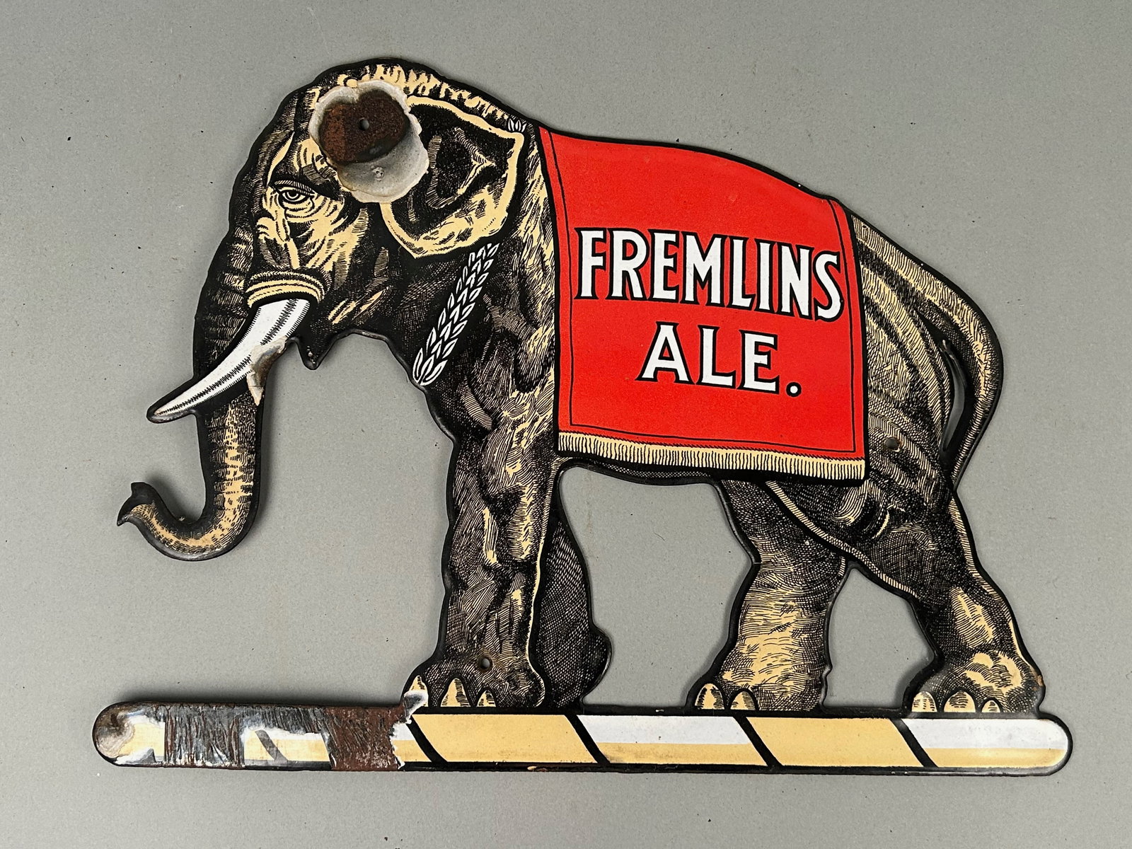 Fremlin's Ale Porcelain Elephant Advertising Sign: porcelain elephant sign Fremlins Ale early 20th century elephant with banner on back. 15”x 12” some chipping and paint loss. See pictures.Provenance: Robert and Jane Cottingham Collection 