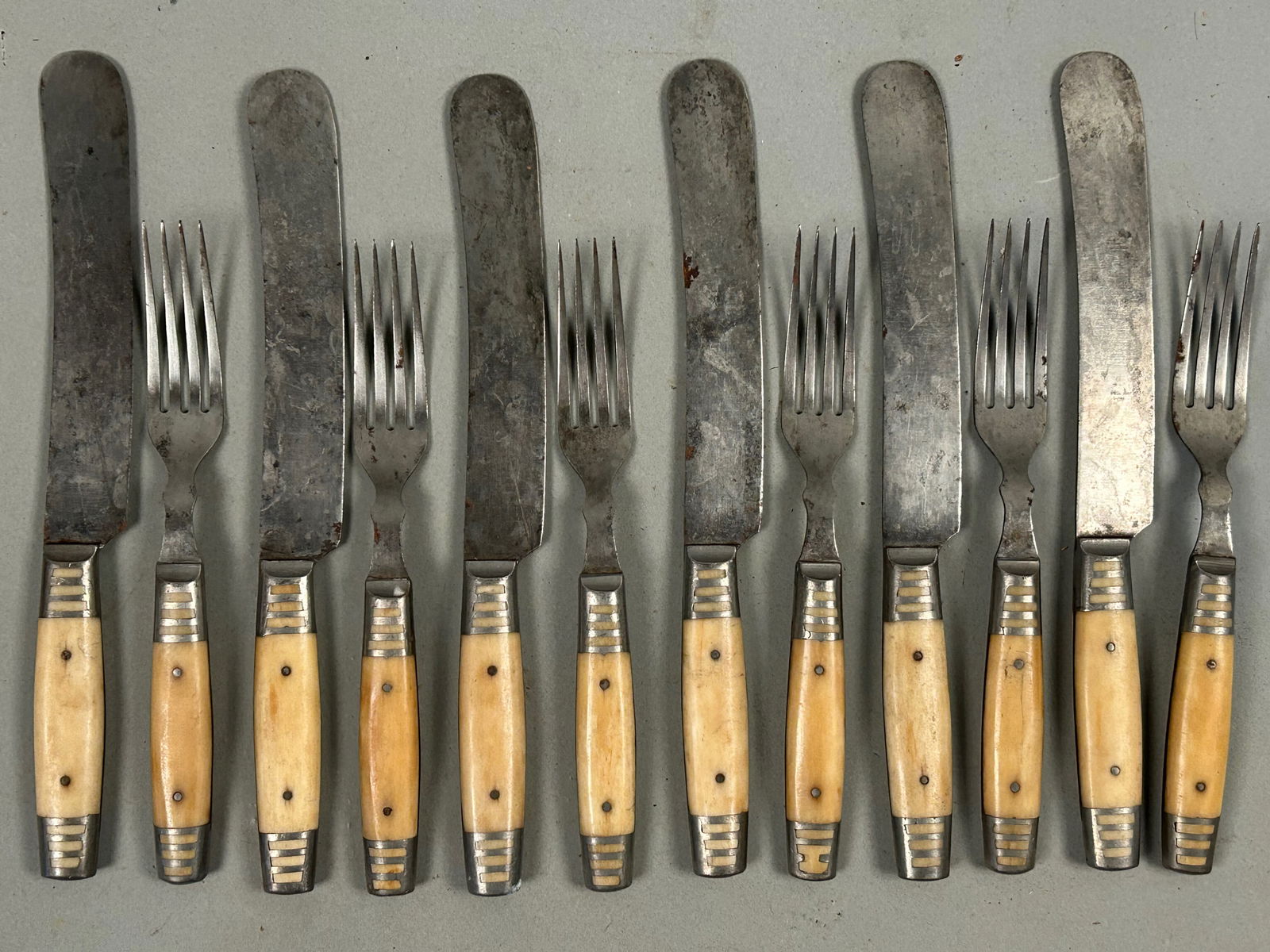 Antique cutlery set: Antique cutlery set of six fork in knives with bone handles. Marked me American cutlery company on the blade of each knife. Knives 9 1/2 inches forks 7 1/2 inches.