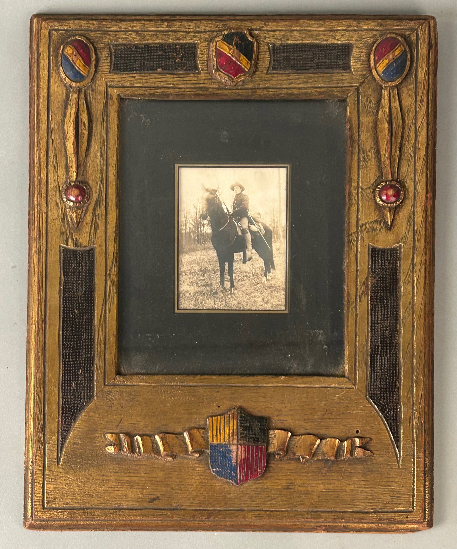 Tramp Art Style Carved Folk Frame with Equestrian Photograph: Tramp Art Style Carved Folk Frame with Equestrian PhotographHand-carved and painted wood frame in the tramp art / folk art style, featuring chip-carved borders, applied shield motifs, and polychrome d