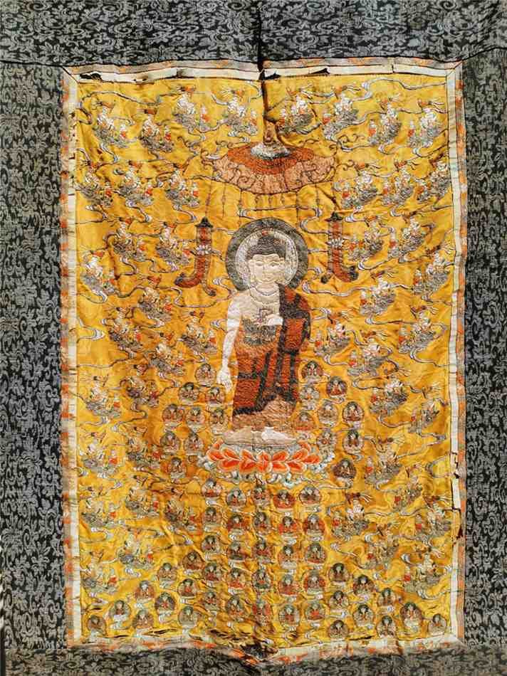 Qing Dynasty thangka: Qing Dynasty thangka, the statue of Sakyamuni sits in the middle, and there are countless embroidered Buddha statues on the side, the main body is golden silk embroidery. The bottom has some damage du