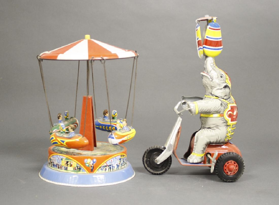 Elephant on Scooter / Go Round: Japan circa 1960. Made of Tin. 8" / 9" Tall. Work well. Pristine Condition.