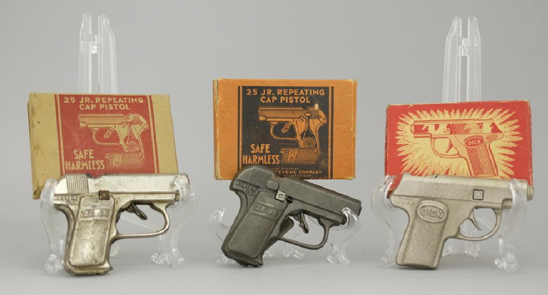 Lot of Three Boxed Cap Guns.: Included: Two 25 Junior Repeating Cap Guns and One "Dick" Cap Gun. Made of Cast Iron. Pristine in Original Boxes.