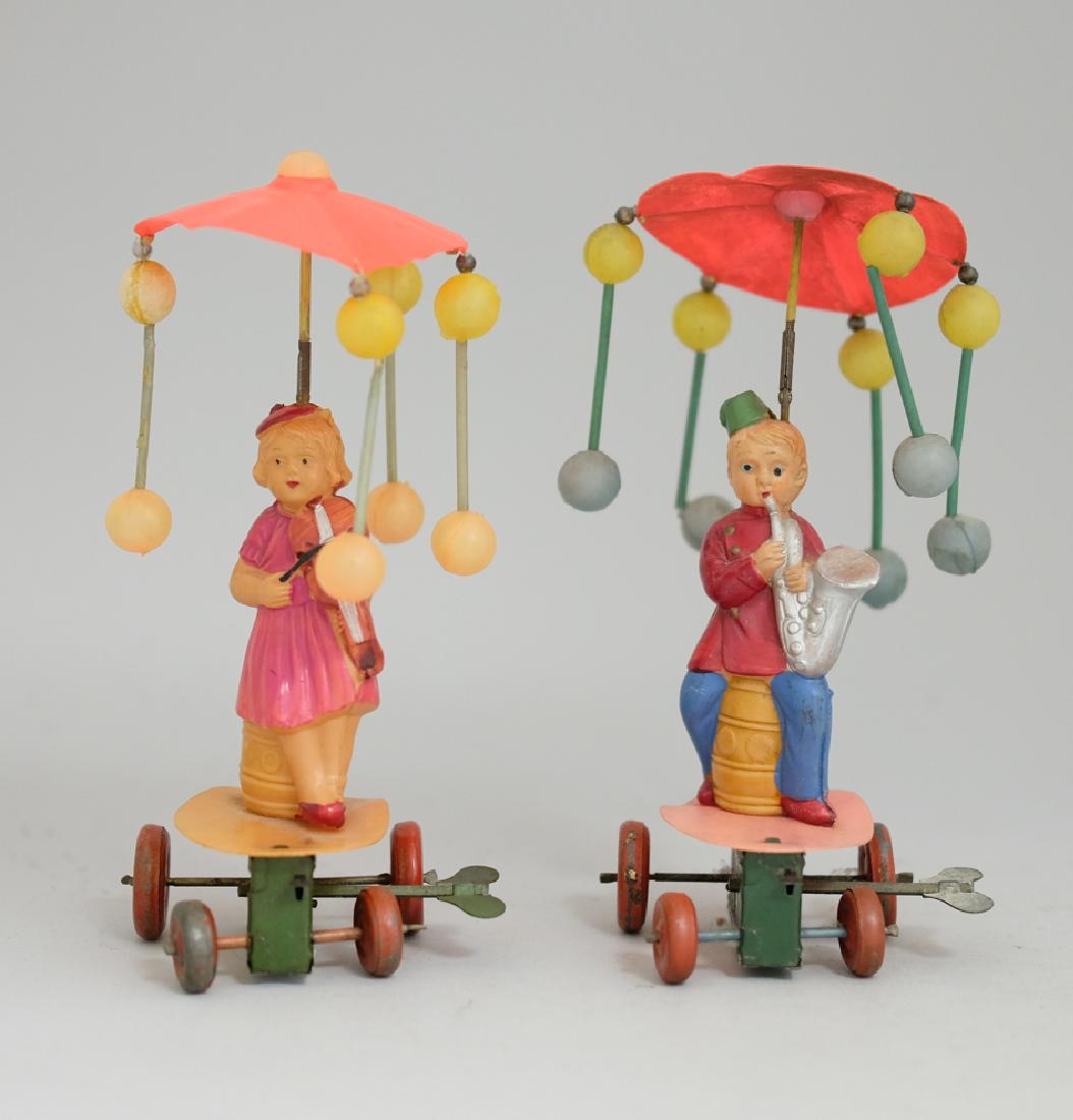 Girl Playing Violin /Boy Playing Saxophone: Made in Japan. Made of Celluloid and Tin. 7.25" Tall. Excellent Condition (Both missing one string of celluloid balloons).