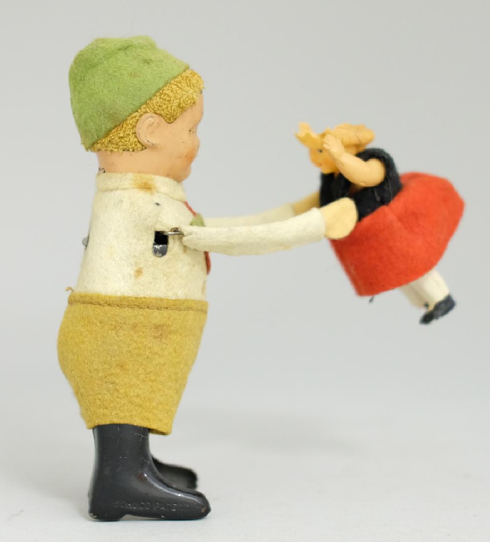 Schuco Boy lifting Little Girl: Made by Schuco. Made of Fabric and Tin. Good Overall (The back of the girls head is broken off and missing).