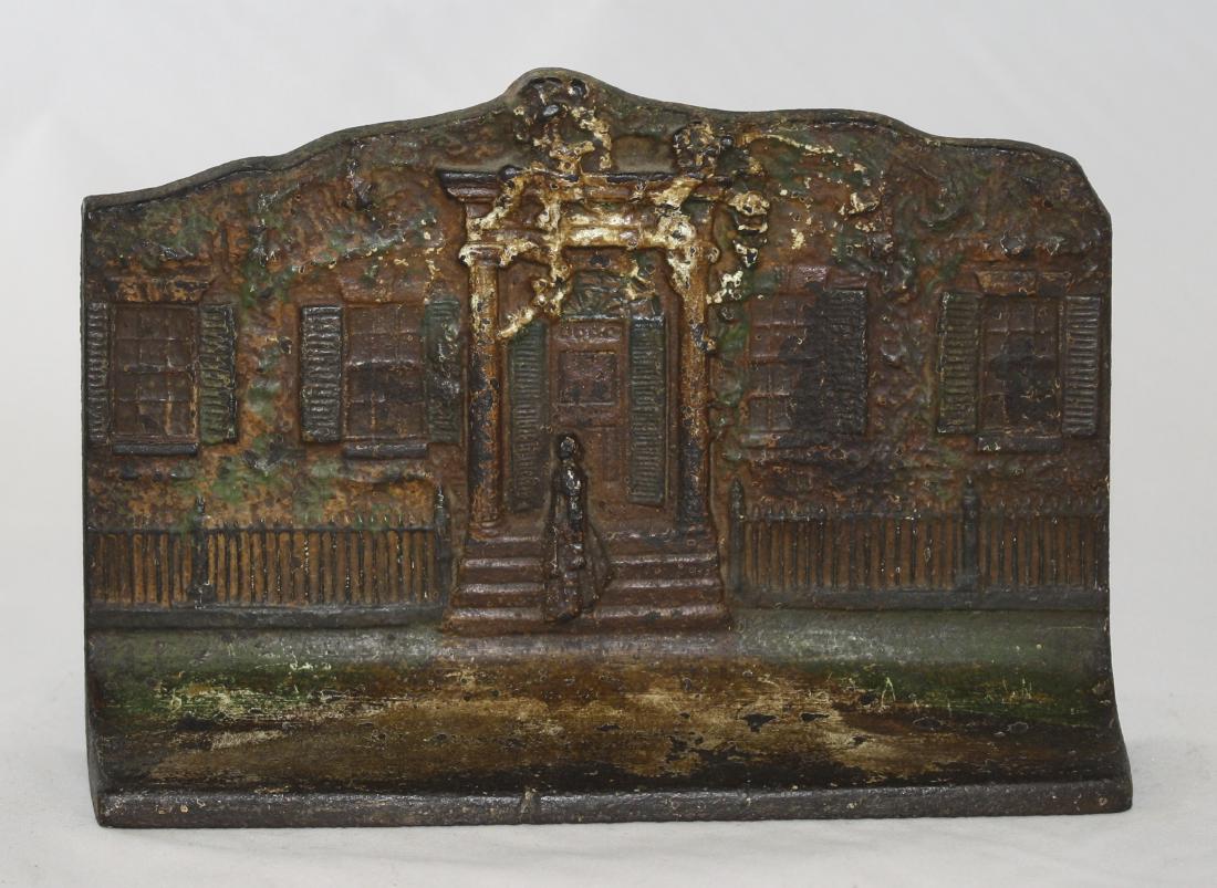 House with Woman Iron Door Stop: Made by Eastern Spec Mfg., Co. Made of Cast Iron. 5 3/4" T x 8 1/2" Wide. Good Condition.