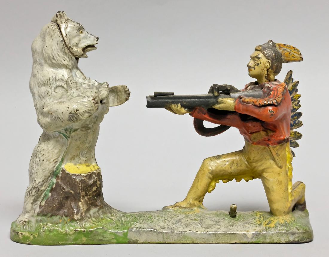 Cast Iron Indian and White Bear Mechanical Bank: Made by J. & E. Stevens Company circa 1890's of Cromwell, Connecticut. Set the rifle, place your coin and then press the lever. The coin will be shot into the bear. Made of Cast Iron. Very Good Condit