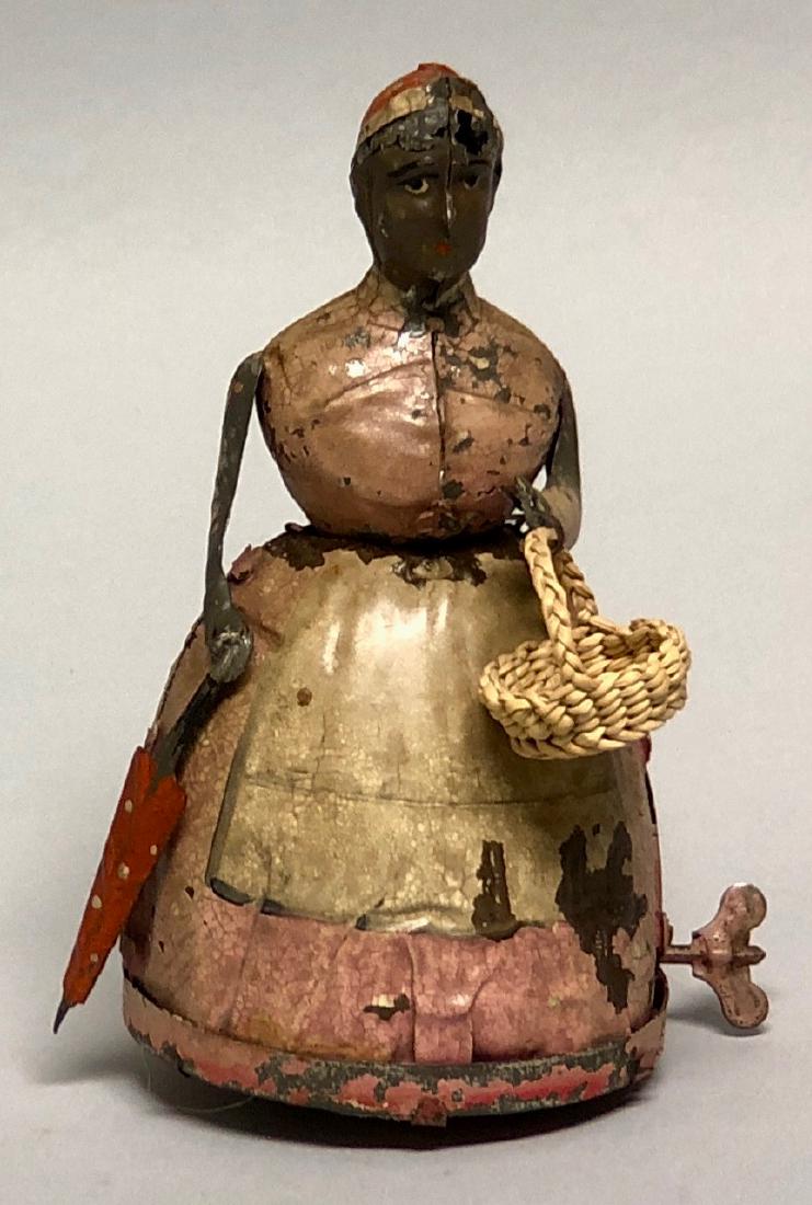 Windup Tin Gunthermann Strolling Woman: Made by Gunthermann of Germany. Made of Tin. 7" T. Works well. Good Condition. Faded Paint.