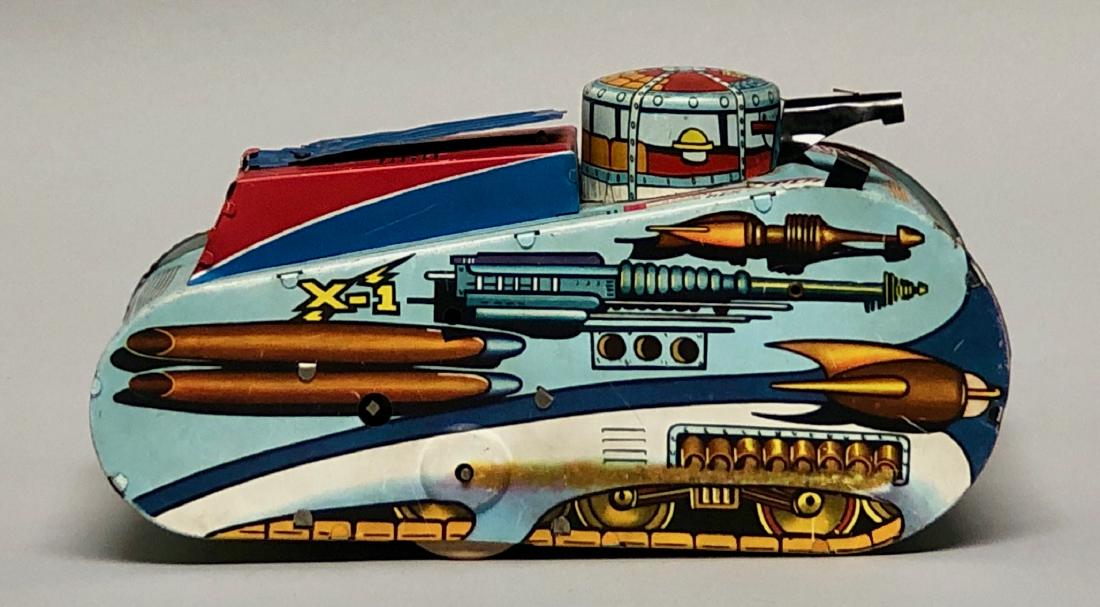Windup Marx Rex Mars Planet Patrol X-1 Tank: Made by Marx. Action: Rolls forward as a soldier pops out of the top aiming his rifle, while simulating sounds of gunfire. Made of Tin with Wooden Wheels. Works well. 10" L. Excellent Condition.