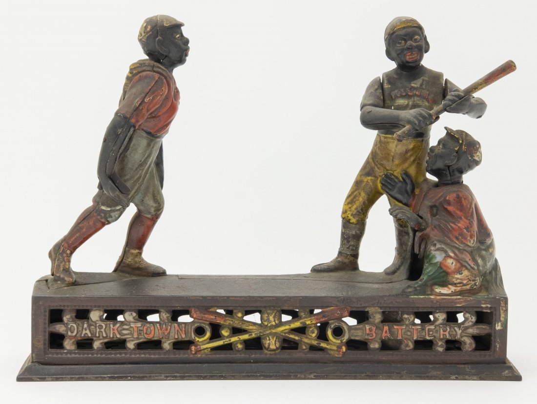Dark Town Battery, Thin Bat Iron Mechanical Bank: Made by J. & E. Stevens Company Cromwell, Connecticut - Circa 1888. He pitches the coin and the batter swings, but the coin sails so quickly by him that it deflects off the chest protector of the catc