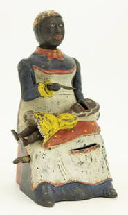 Mammy with Child Cast Iron Mechanical Bank: Made by Kyser & Rex Company Philadelphia, Pennsylvania - Circa 1884. Coins can either be fed into the infant’s mouth from Mammy’s spoon or through her apron pocket. Made of Cast Iron. Fine Conditi