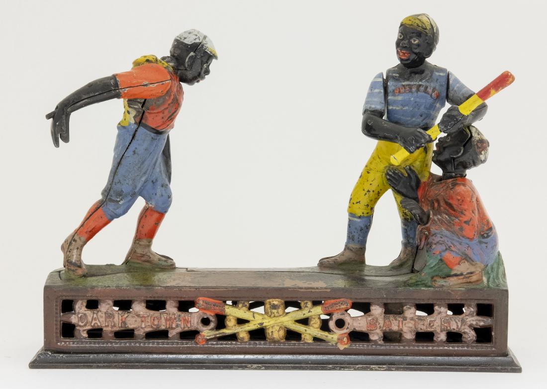 J. & E. Stevens Dark Town Battery Cast Iron Bank: Made by J. & E. Stevens Company Cromwell, Connecticut - Circa 1888. He pitches the coin and the batter swings, but the coin sails so quickly by him that it deflects off the chest protector of the catc