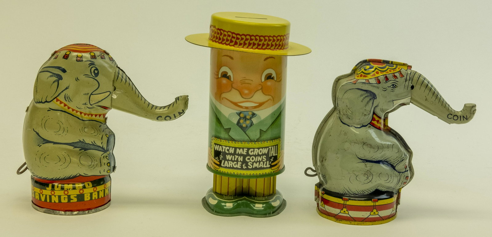 Three Tin Semi Mechanical Banks: Includes: Jumbo Made in England, Watch Me Grow by Apex Novelty Co. and Elephant Raises Trunk by J. Chein. Jumbo is scarce. Made of Tin. Very Fine to Excellent Condition.
