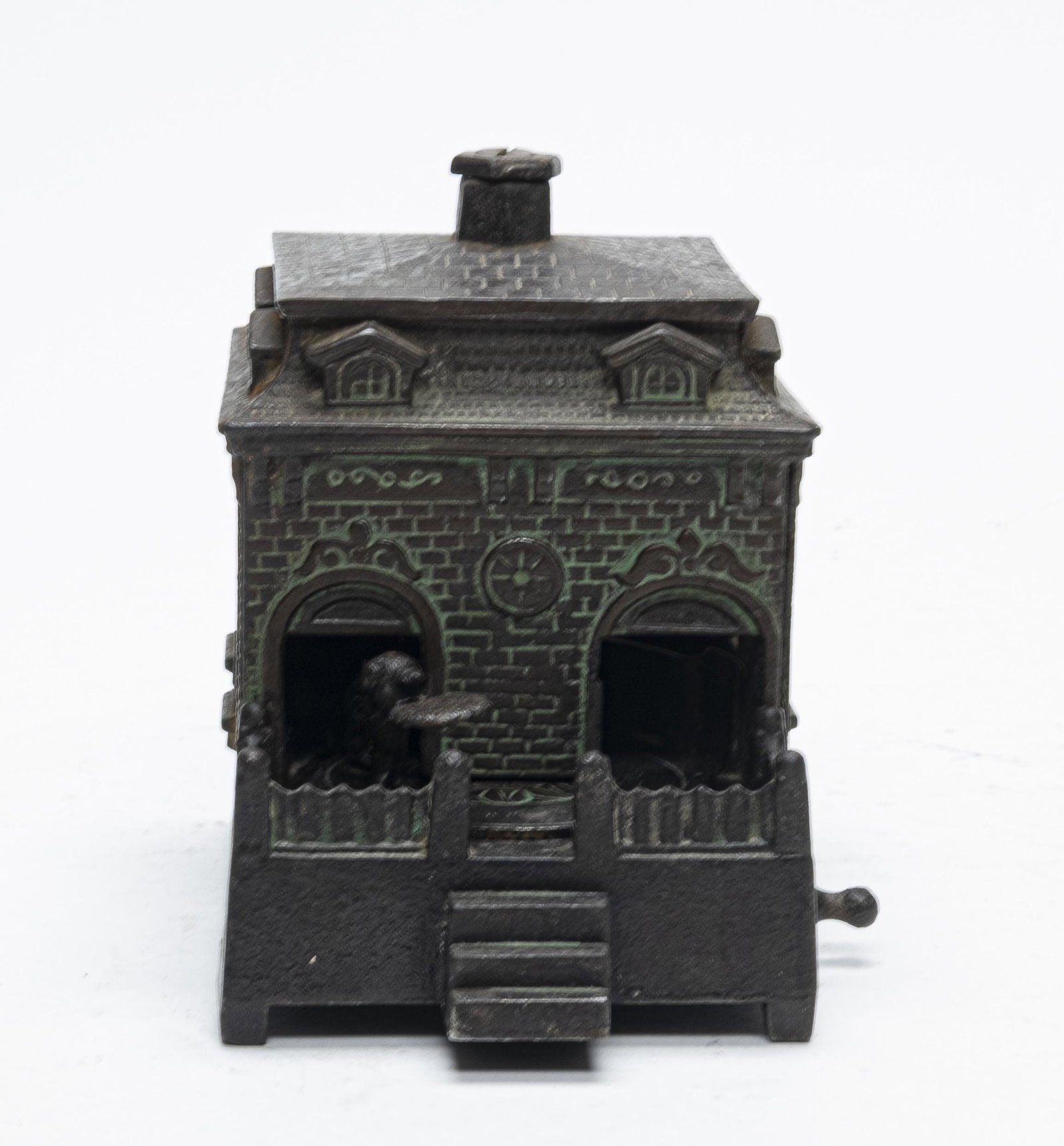 Dog on Turntable Iron Bank with Green Wash: Made by H. L. Judd. This bank has a great green wash. Turn the crank and the dog enters the building and deposits the coin. Made of Cast Iron. Fine Condition.