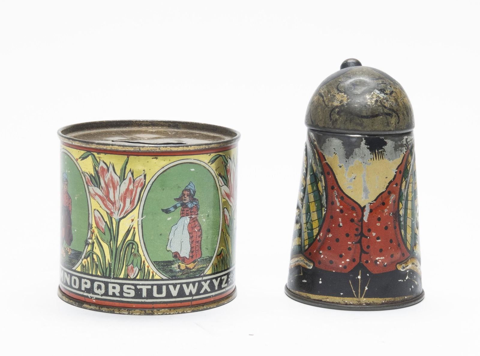 Mama Katz & Dutch Alphabet Tin Still Banks: Made in Germany. The Dutch Boy and Girl tin has the Alphabet and numbers 1 to 0 around the base. 2 1/4" - 3 3/4" Tall. Made of Tin. Good to Fine Condition.