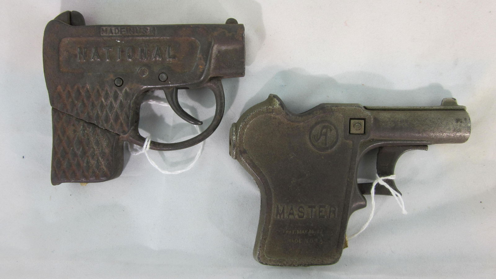 Two 1920s Repeater Cap Roll Pistols.: Andes "Master" cap roll pistol, patent date May 1922, 4 1/2" long, worn nickel plate, with "National" repeater pistol circa 1920, 3 3/4" long. 2 pieces. Condition very good, nickel plate worn on "Mast