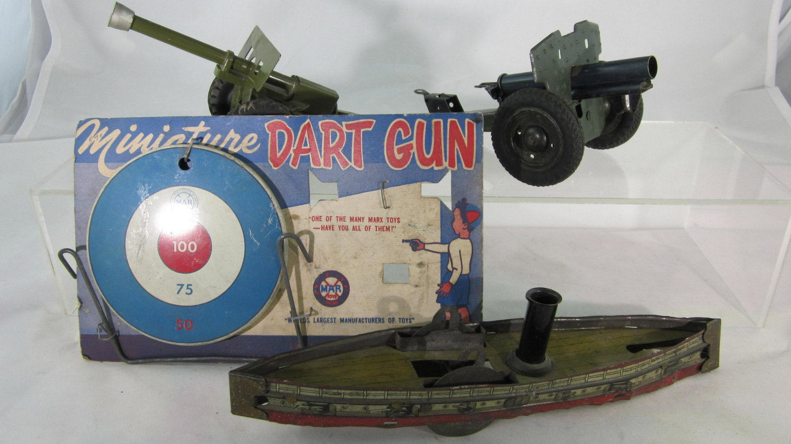 Assorted Tinplate Toy Assortment.: Marx Dart Gun Target (4" Diameter) on original packaging card, tinplate cannon with rubber wheels made in U.S. Zone Germany, Tinplate Howitzer & incomplete Tin-litho 9 1/2' long boat by unknown makers