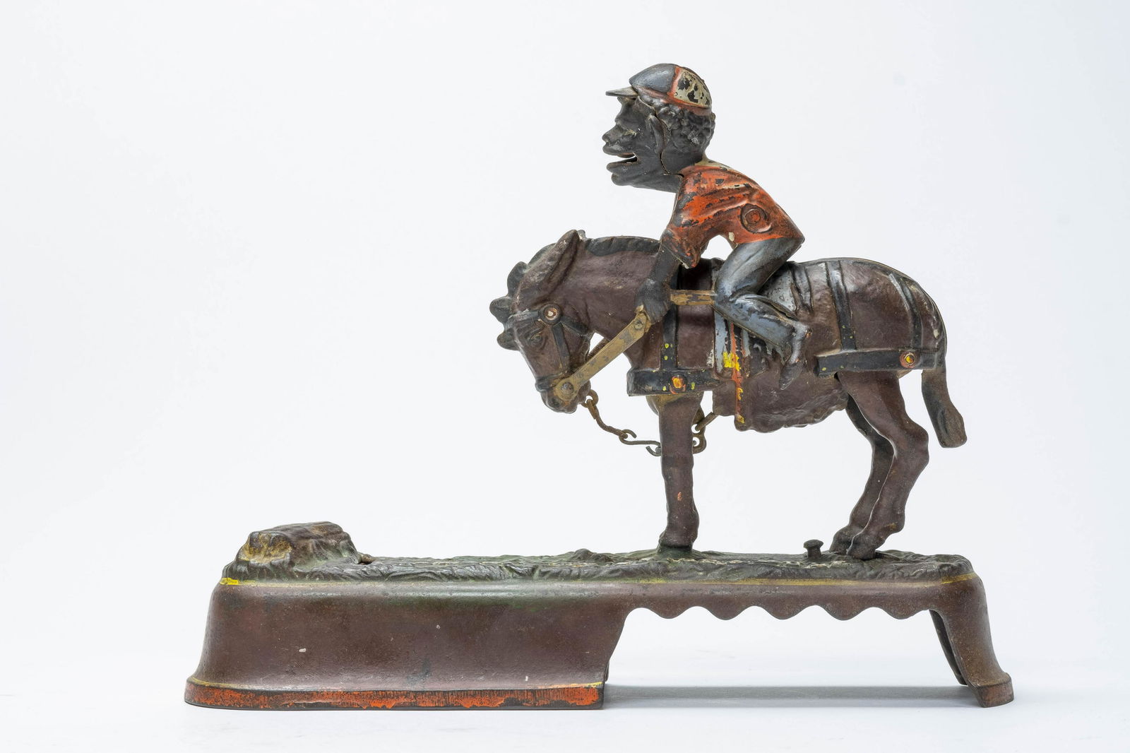 I Always Did 'Spise a Mule Jockey Iron Bank: J. & E. Stevens. Made of Cast Iron. Place a coin in the Jockey's mouth. Press the lever and the mule throws the jockey. The coin is deposited into the tree stump. Worked when tested. Very Good Conditi