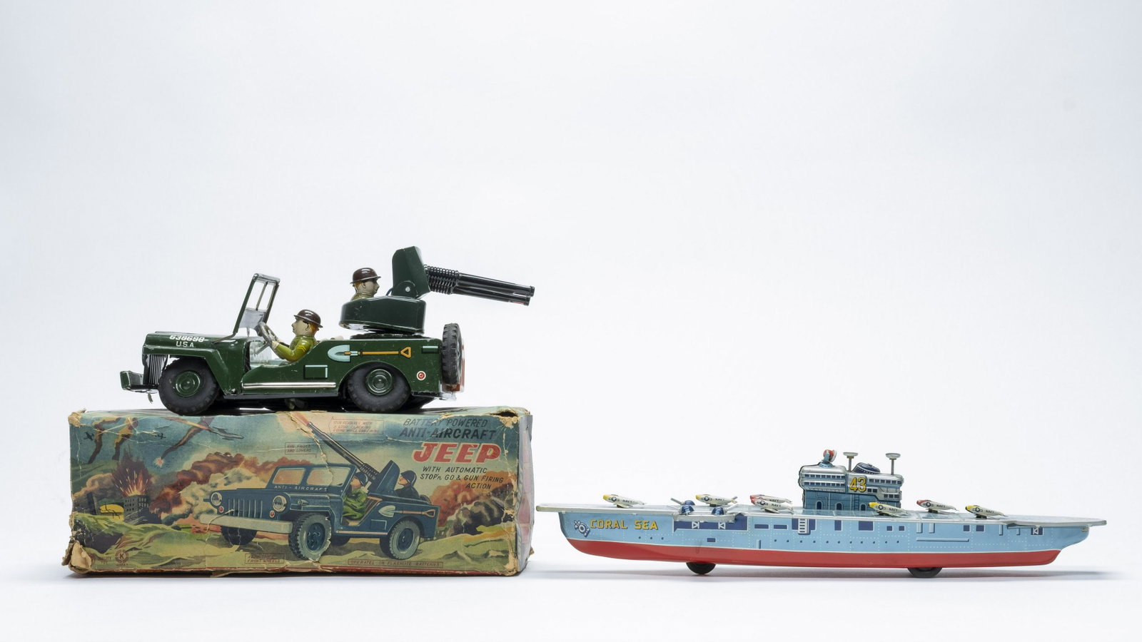 Jeep and Aircraft Carrier Toys Japan: Battery Op Anti-Aircraft Jeep made by "K" of Japan. Friction Coral Sea Aircraft Carrier made by Bandai of Japan. 9" - 15" Long. Made of Tin. Jeep does not work. Coral Sea worked when tested. Excellent
