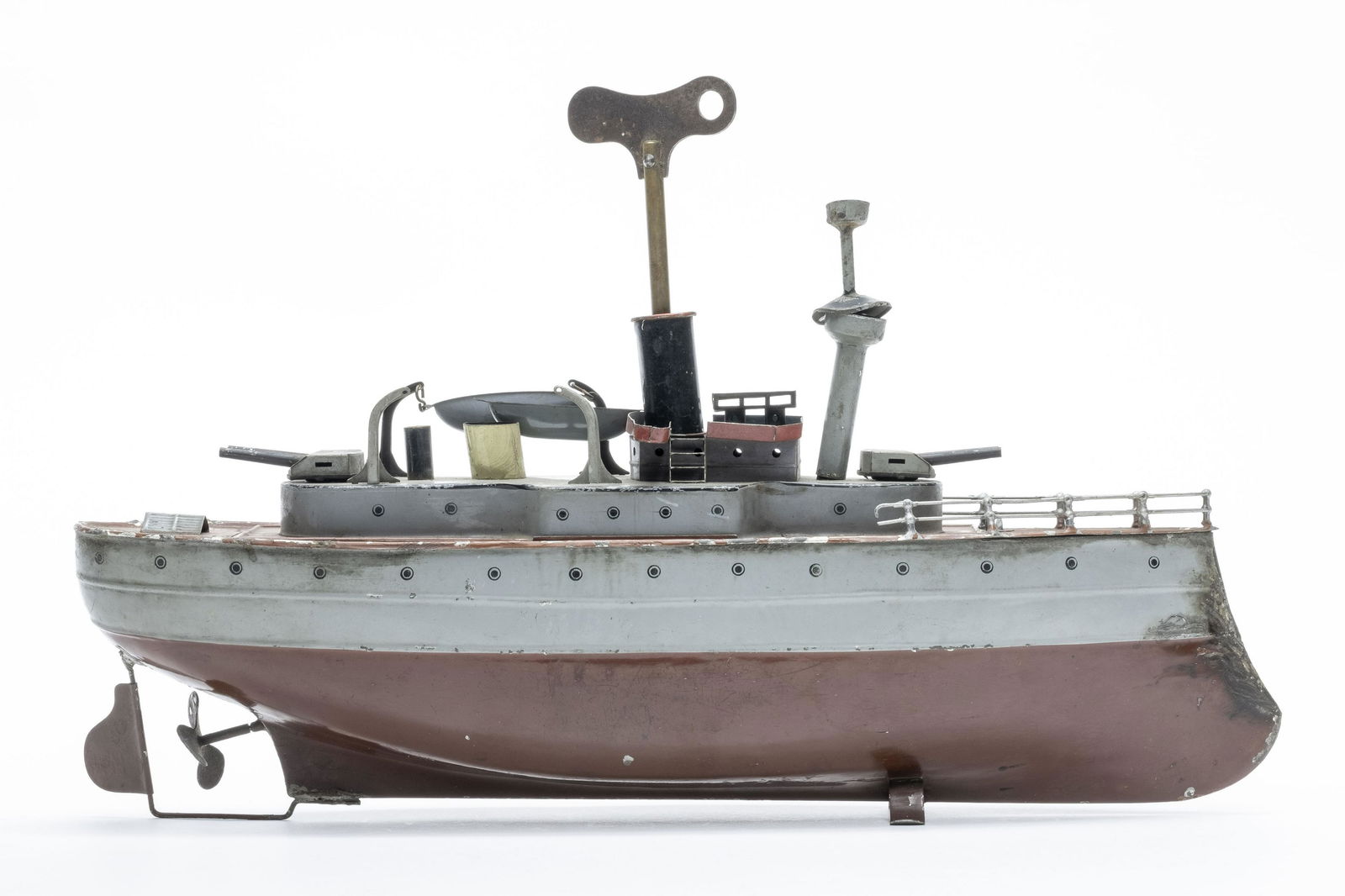 Fleischman Battleship: Made by Fleischman. 15" Long. Worked when tested. Fine Overall. Front re-seamed. Crows nest and flag must be reattached. Retains a key.