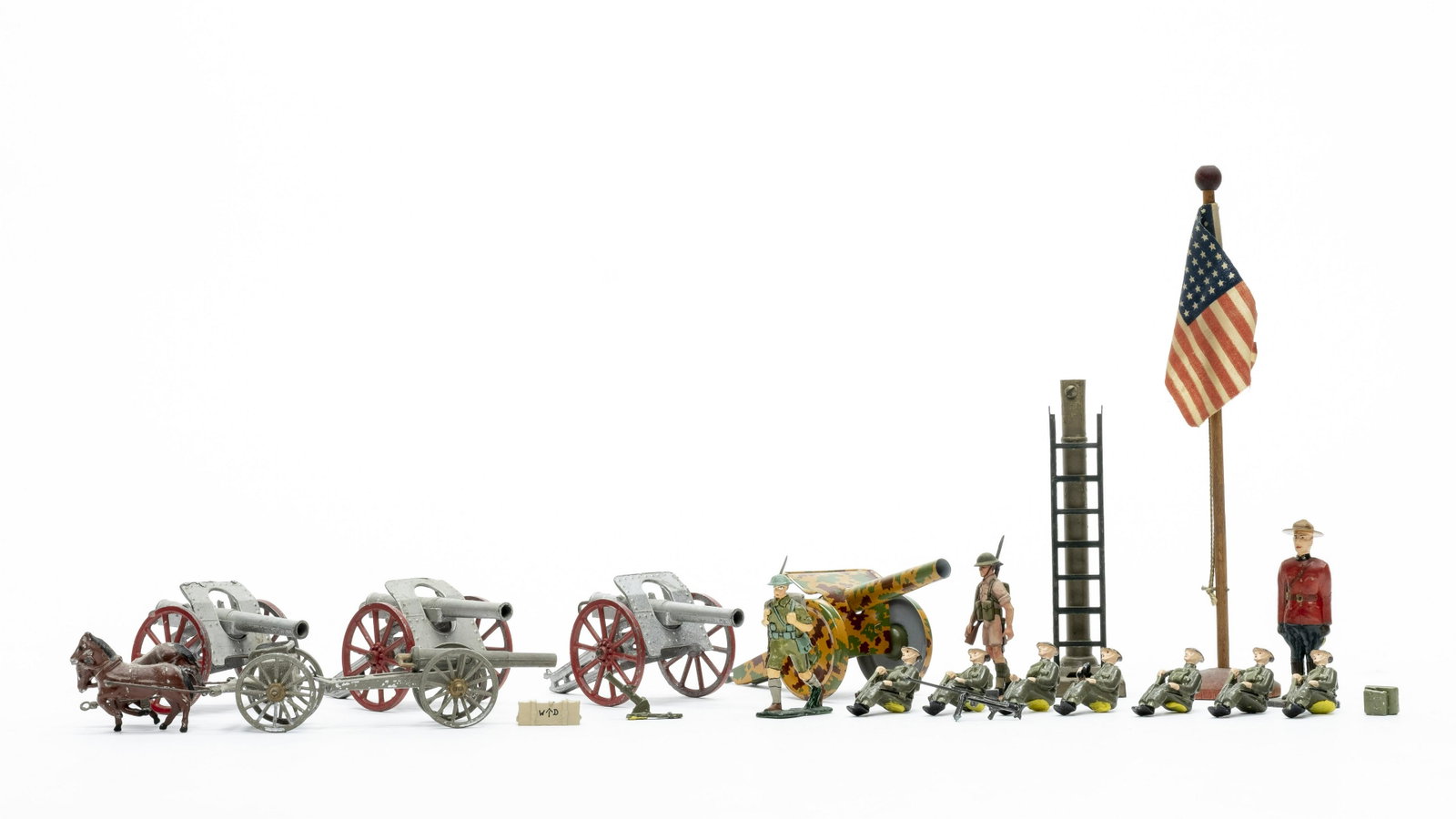 Military Toy Group of 19: Includes: 5 Cannon, 1 Flag Pole, 9 Figures, 1 Mortar, 1 Machine Gun, 1 Back Pack and 1 Crate. Made of Tin, Lead, Wood and Plastic. Very Fine to Excellent Condition.