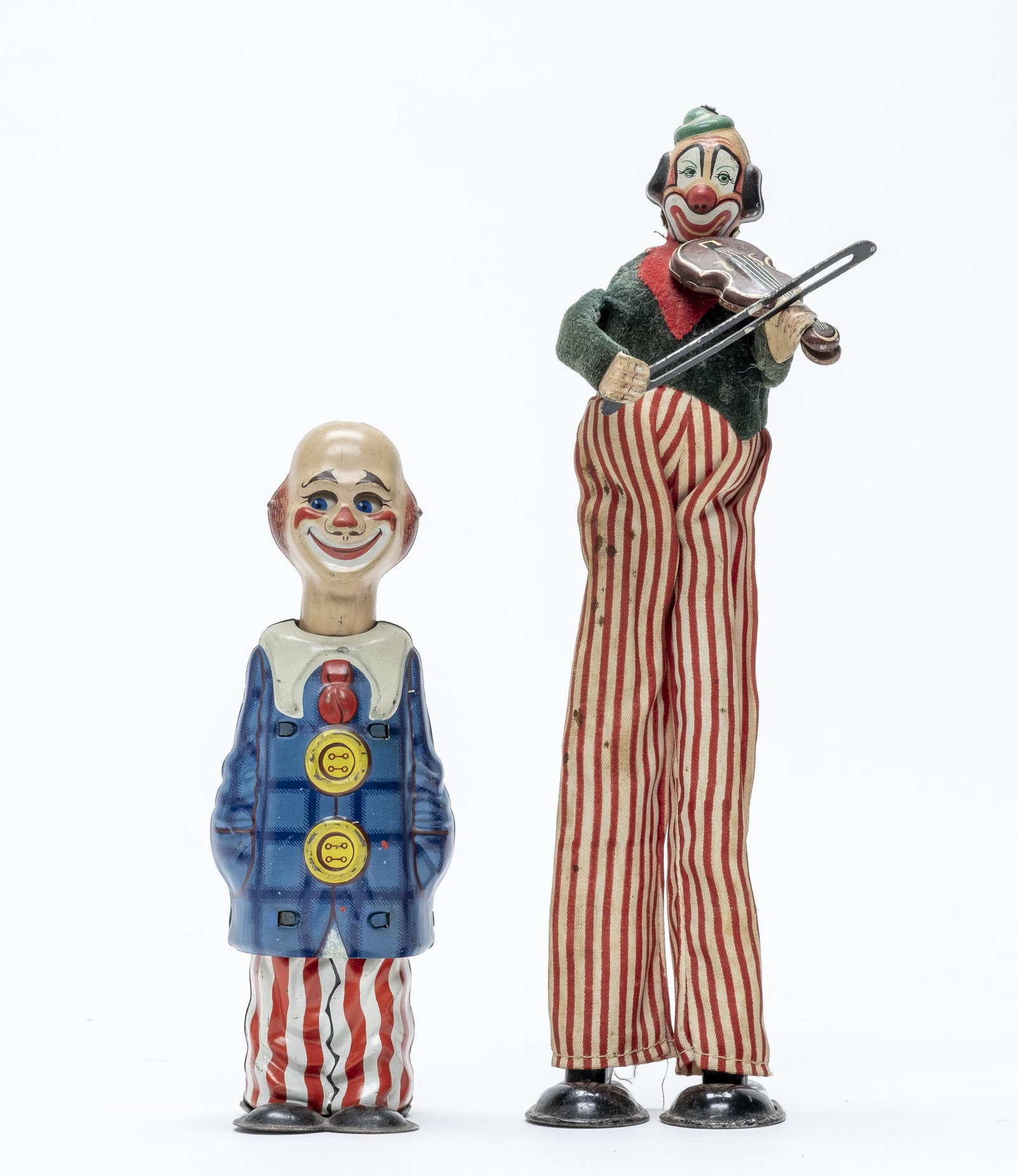 TPS Clown on Stilts & U. S. Zone Germany Clown: Made of Tin. 6" - 9 1/2" Tall. U. S. Zone Germany clown worked when tested. Clown on Stilts mechanism is frozen. Fine to Excellent Condition. No key.