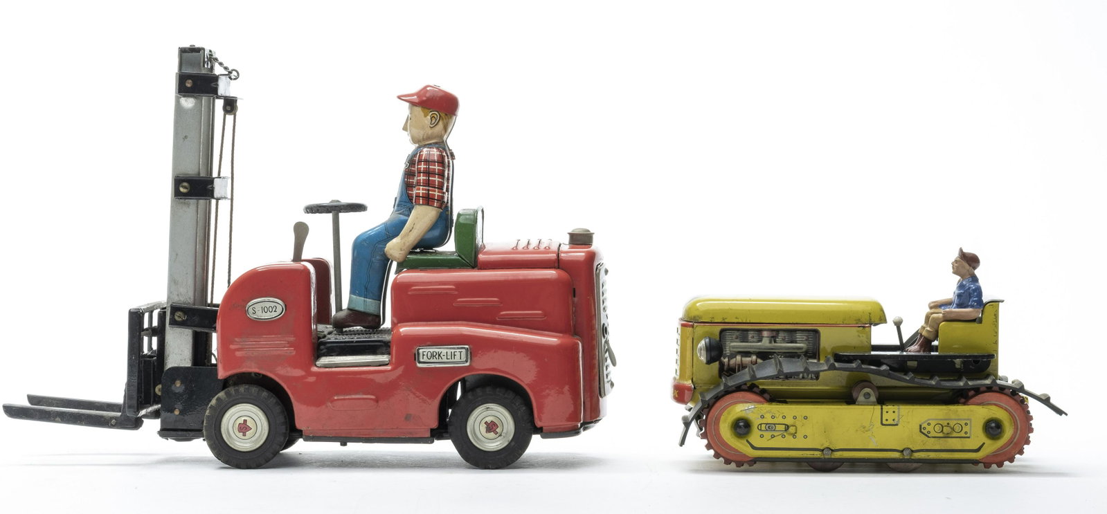 Forklift / Arnold Tractor: Japanese / West German 1950's/1960's. The Forklift is battery operated and does not work. The tractor is friction driven and works. Fine Condition. One tread is broken, but mostly present.