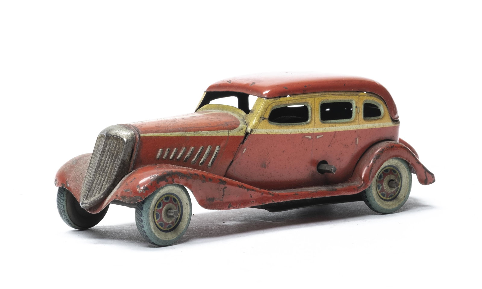Prewar Japanese Saloon Car: Japanese 1930's. 6 1/4" Long. Although unmarked the colorful wheels lead us to believe that it is Japanese. Worked when tested. Fine Condition. Minor dents. No key.