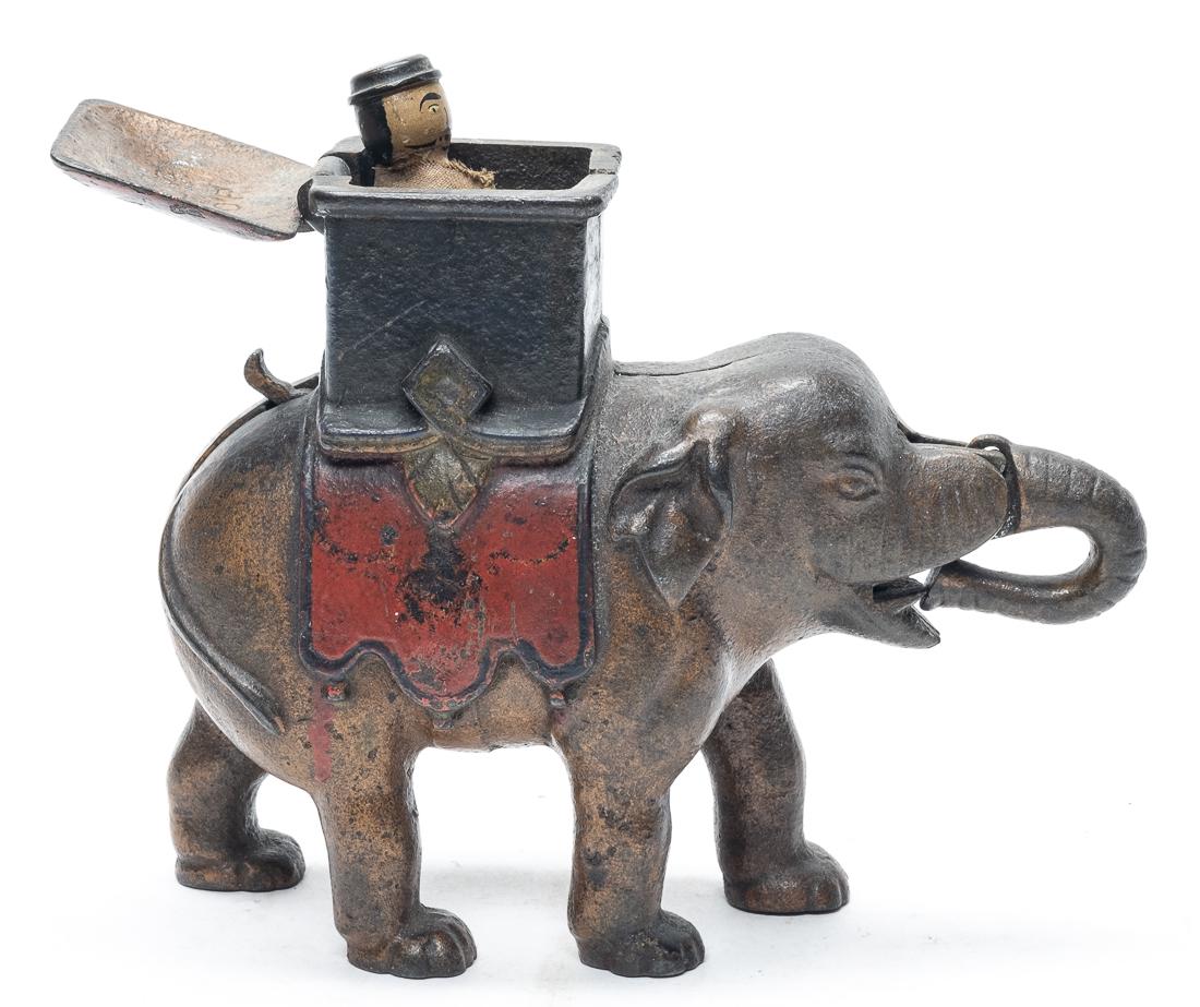 Elephant - Man Pops Up Iron Bank: American - 1890 - 7" Long. Set the man in place and place a coin in his mouth. Press the lever and the man pops up as the coin is deposited. Very Good (Needs a Cleaning).